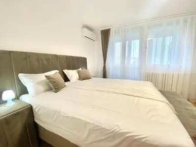 a bedroom with a large bed with white sheets at Apartman I&T in Banja Luka
