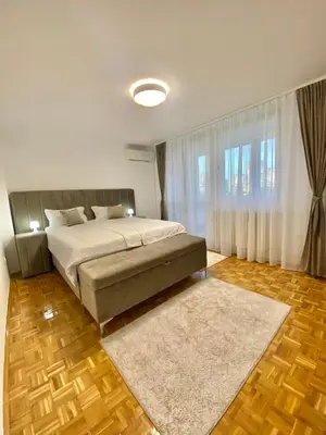 a bedroom with a large bed and a large window at Apartman I&T in Banja Luka