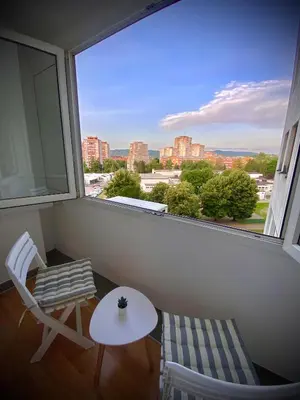 a room with a large window with a table and a chair at Apartman I&T in Banja Luka