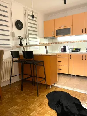 a kitchen with two chairs and a table and a counter at Apartman I&T in Banja Luka