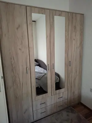 a large wooden cabinet with mirrors in a bedroom at Vikendica 