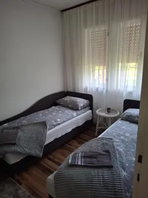 a bedroom with two beds and a small table at Vikendica 