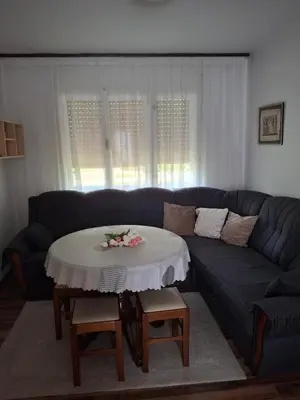 a living room with a blue couch with a table at Vikendica 