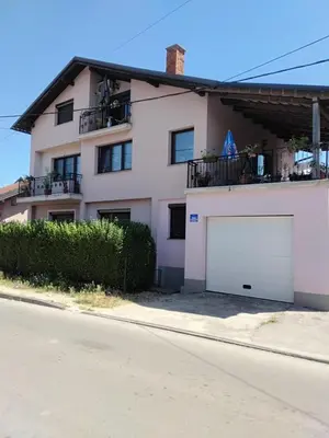 a white house with a large white garage at Apartman Aldina in Bihać