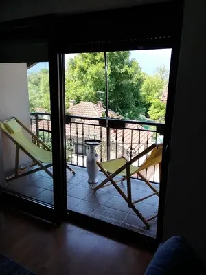 a room with two chairs and a view of a balcony at Apartman Aldina in Bihać