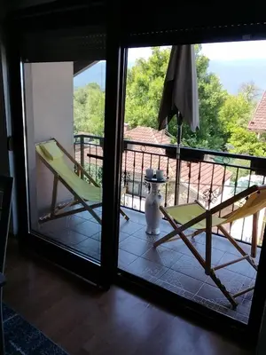 a room with a balcony with a chair and a window at Apartman Aldina in Bihać