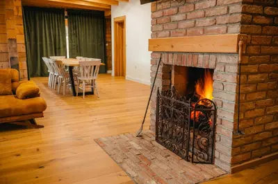 a brick fireplace in a living room with a table at Villa Dos Padrinos in Banja Luka