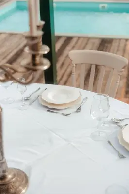 a table with a white plate and glasses on it at Villa Dos Padrinos in Banja Luka