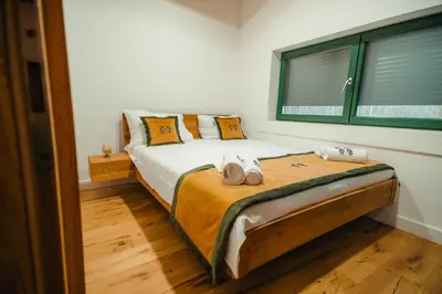a bedroom with a bed with two pillows and a window at Villa Dos Padrinos in Banja Luka