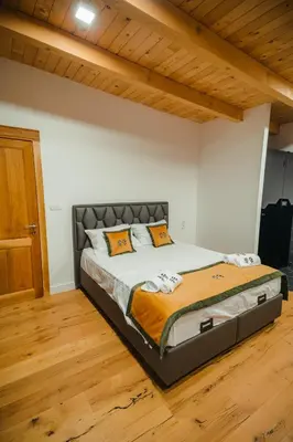 a large bed in a room with a wooden floor at Villa Dos Padrinos in Banja Luka