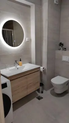 a bathroom with a sink and a toilet and a mirror at Apartment Lena 51 in Banja Luka