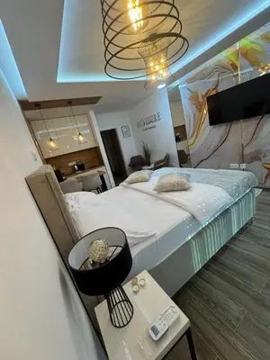 a bedroom with a large bed and a table at Belvedere Apartment in Doboj