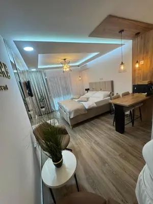 a living room with a bed and a table and a dining room at Belvedere Apartment in Doboj