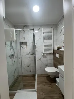 a bathroom with a shower and a toilet at Belvedere Apartment in Doboj