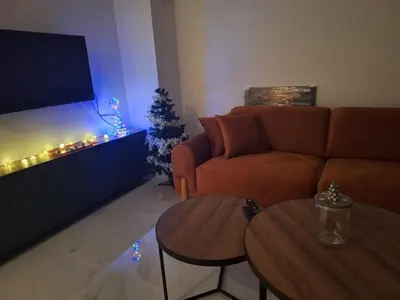 a living room with a couch and a christmas tree at SD apartman - Trn in Ivišovo Greblje