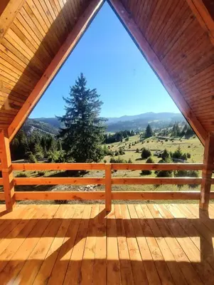 a view from the front porch of a cabin with a large window at Woodenhouse Ede Vlasic in Kutlovac