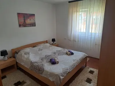 a bedroom with a bed with two teddy bears on it at Apartman Orijent in Kulen Vakuf