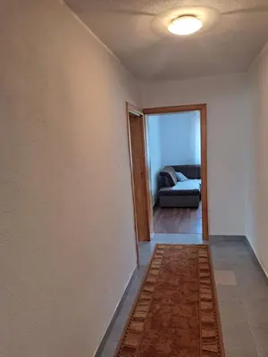 a living room with a couch and a hallway at Apartman Orijent in Kulen Vakuf