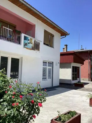 a white house with a balcony and a courtyard at Konak kod Daće in Drvar
