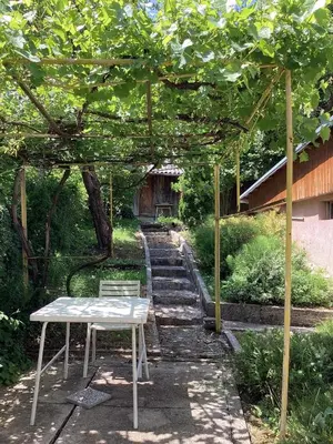 a table and chairs sitting under a pergola at Konak kod Daće in Drvar