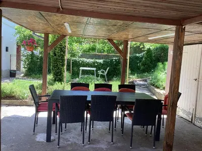 a table and chairs under a pavilion in a yard at Konak kod Daće in Drvar