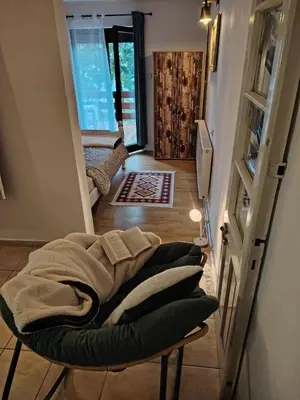 a living room with a couch and a room with a window at Domus Foresta Apartmani in Brdo