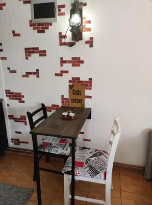 a table and two chairs in front of a wall at Domus Foresta Apartmani in Brdo