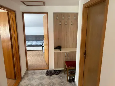 a room with a mirror and a bedroom with a bed at Apartman Bojan in Prnjavor