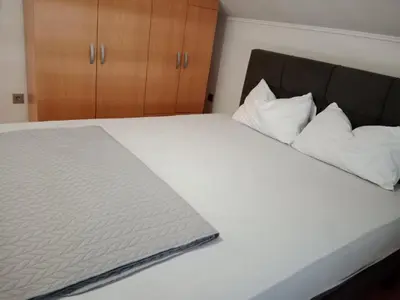 a bed with white sheets and pillows on it at Apartman Bojan in Prnjavor