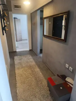 a hallway with a mirror and a television on a wall at Apartman Mejdan in Banja Luka
