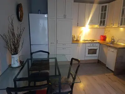 a kitchen with a glass table and a refrigerator at Apartman Mejdan in Banja Luka