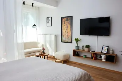 a bedroom with a bed and a television on a wall at Lovely and cozy apartment Lena in Zenica