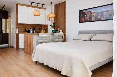 a bedroom with a white bed and a kitchen at Lovely and cozy apartment Lena in Zenica