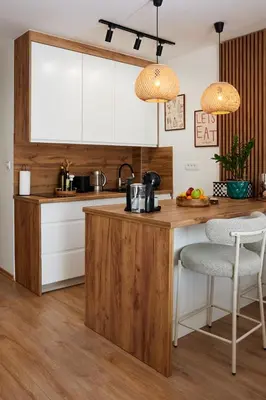 a kitchen with white cabinets and a wooden island with two chairs at Lovely and cozy apartment Lena in Zenica