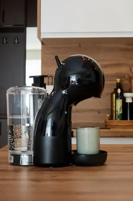 a black mixer sitting on a counter next to a cup at Lovely and cozy apartment Lena in Zenica