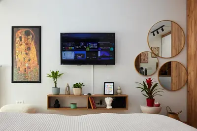 a bedroom with a bed and a tv on a wall at Lovely and cozy apartment Lena in Zenica
