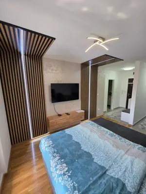 a bedroom with a large bed with a flat screen tv at Apartman Garden 44 in Doboj
