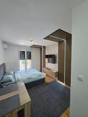 a bedroom with a bed and a tv in it at Apartman Garden 44 in Doboj