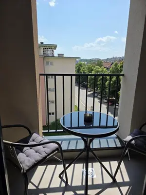 a balcony with a table and chairs and a view of a street at Apartman Garden 44 in Doboj