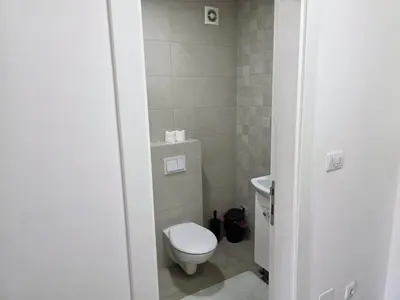a small bathroom with a toilet and a sink at Apartman Garden 44 in Doboj