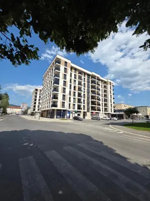 a large white building on the side of a street at Apartman Garden 44 in Doboj