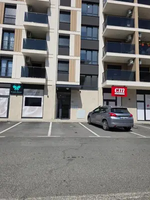 a car parked in a parking lot in front of a building at Apartman Garden 44 in Doboj