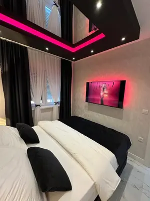 a bedroom with two beds and a tv on the wall at Apartment Aristos in Modriča