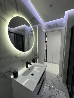 a white bathroom with a sink and a mirror at Apartment Aristos in Modriča