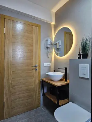 a bathroom with a sink and a wooden door at Apartments NIM in Jajce