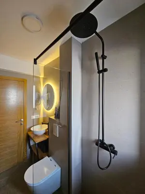 a bathroom with a shower with a toilet and a sink at Apartments NIM in Jajce