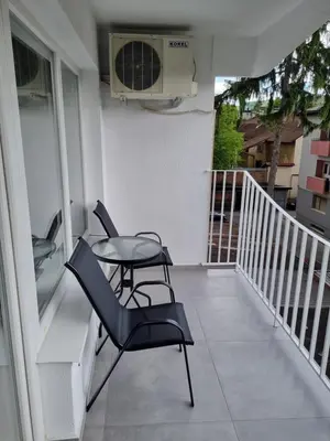 a balcony with two chairs and a table and a fan at Nika-Simka in Banja Luka