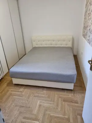 a bed in a room with a wooden floor at Nika-Simka in Banja Luka