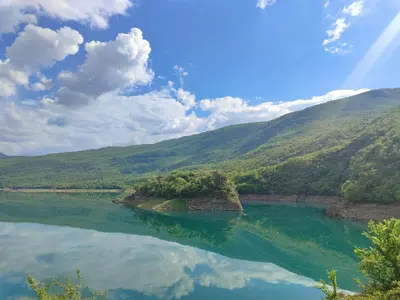 a large body of water with mountains in the background at Bungalovi Narandža Ramsko jezero