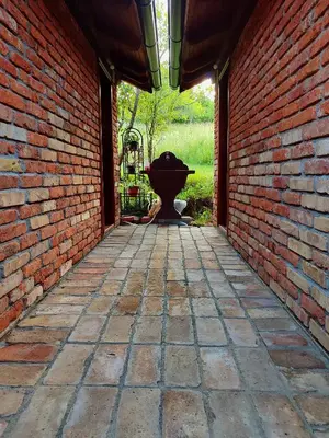 a brick hallway with a fountain in a brick wall at Bungalovi Narandža Ramsko jezero